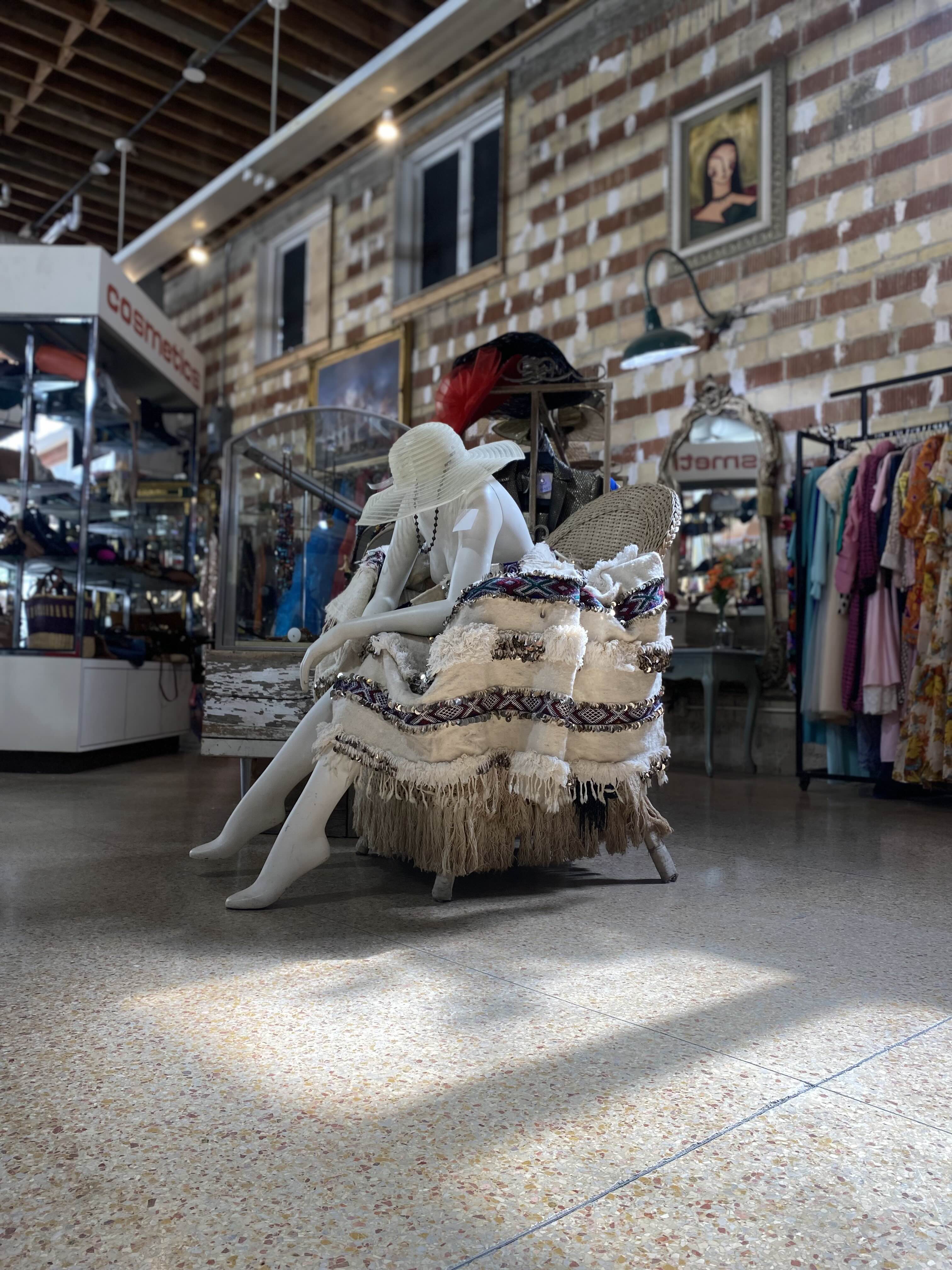 photo of a maniquin siting on a chair in a very fashionable pose